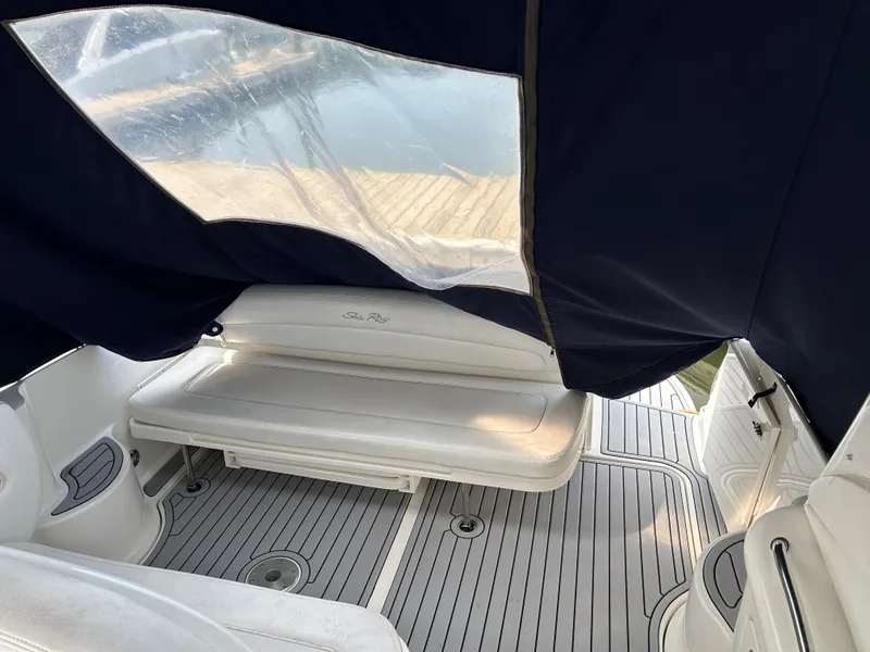 Slide: The Image of 2005 Sea Ray 300 Sundancer interior with seating and canopy, dockside view. - 7
