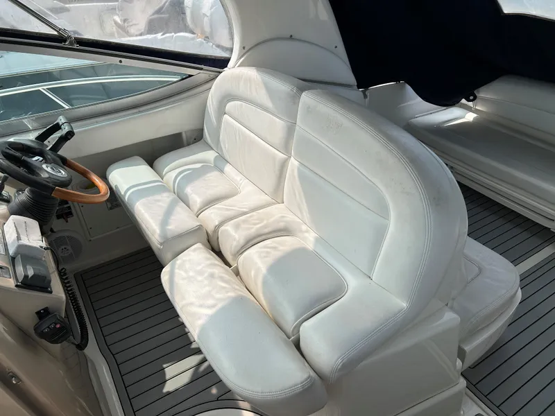Slide: The Image of 2005 Sea Ray 300 Sundancer interior with white leather seating and wooden steering wheel. - 8