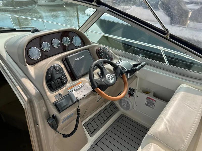Slide: The Image of 2005 Sea Ray 300 Sundancer helm with steering wheel, gauges, and navigation system. - 9