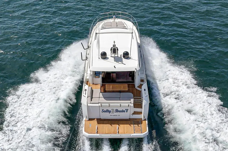 Slide: The Image of 2019 Prestige 520S yacht cruising on open water, rear view, creating waves. - 12