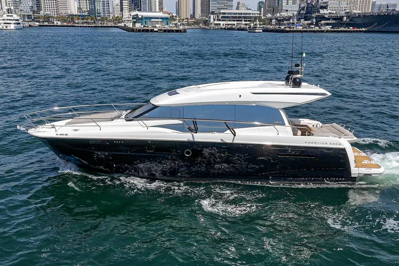 Slide: The Image of 2019 Prestige 520S yacht cruising in a city harbor. - 2