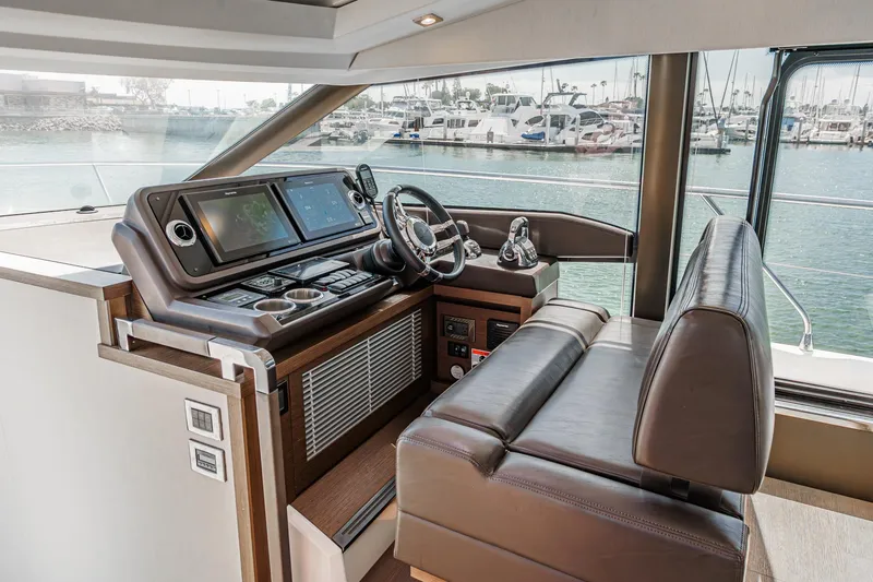 Slide: The Image of 2019 Prestige 520S yacht helm with leather seating and modern navigation controls. - 34