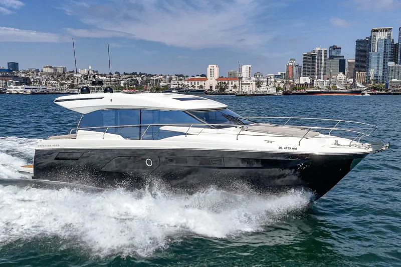 Slide: The Image of 2019 Prestige 520S yacht cruising on water with city skyline in background. - 5