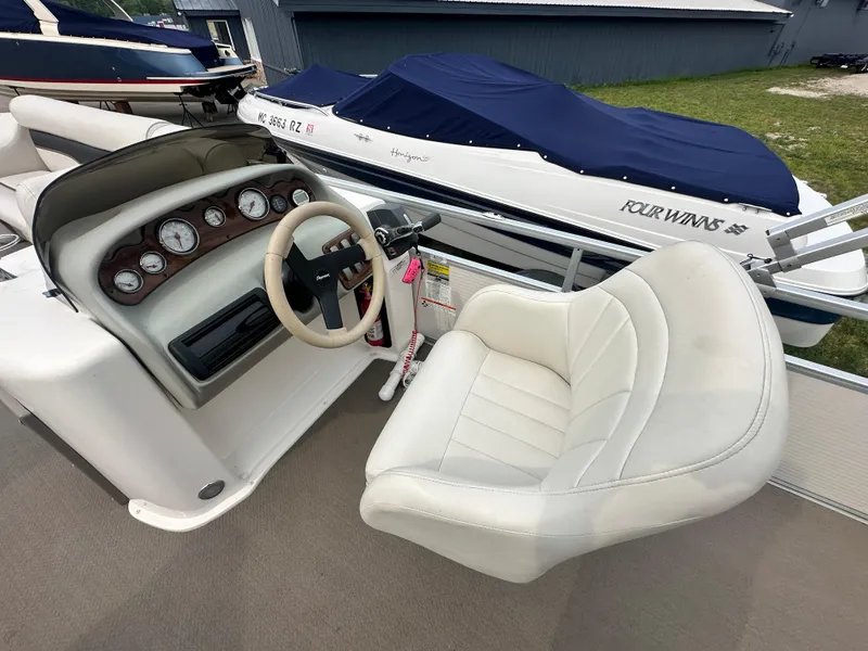 Slide: The Image of 2008 Premier 240 SunSpree boat interior with steering wheel and white captain's chair. - 3