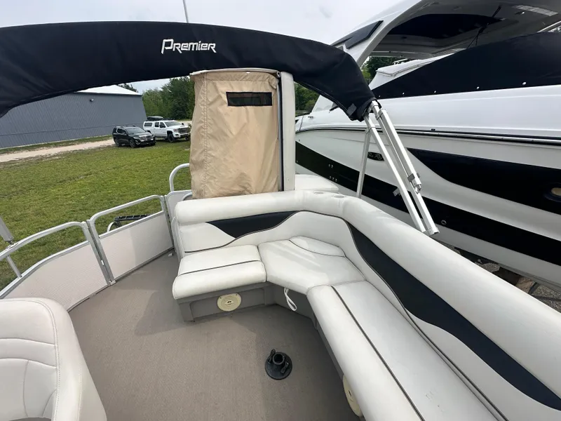 Slide: The Image of 2008 Premier 240 SunSpree pontoon boat with cushioned seating and canopy, docked beside another boat. - 7