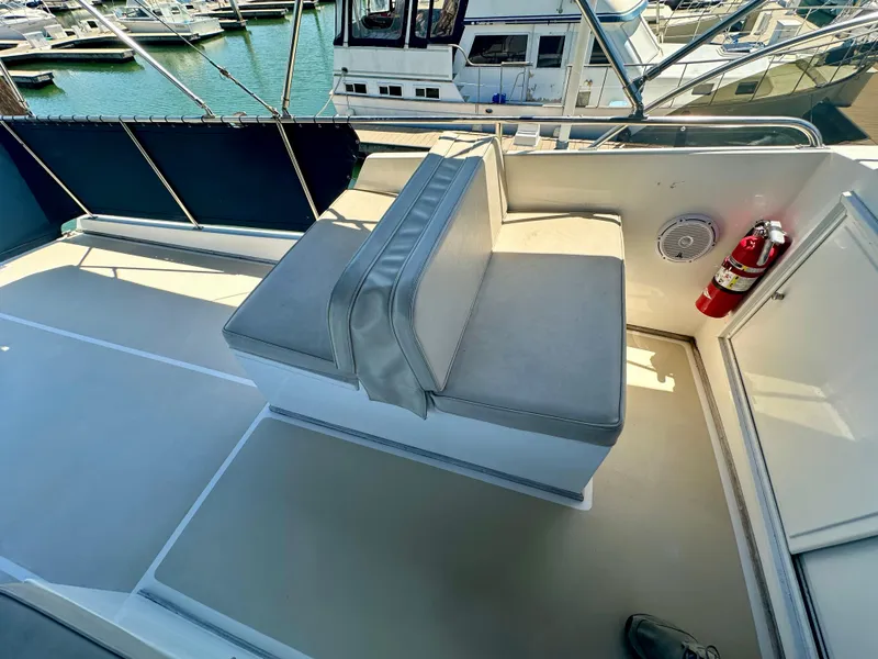 Slide: The Image of 1994 Grand Banks 42 Classic yacht seating area with fire extinguisher and marina view. - 12