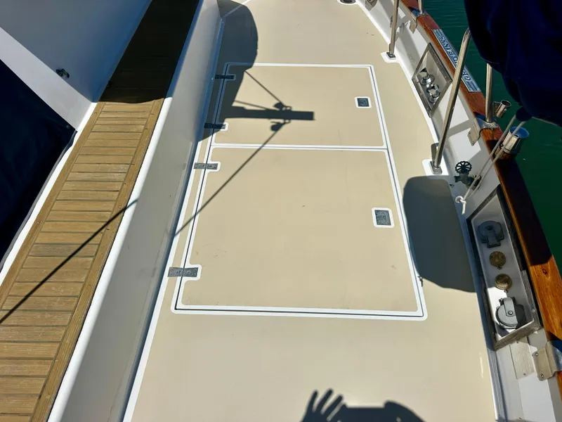 Slide: The Image of Deck of 1994 Grand Banks 42 Classic yacht with wooden trim and storage hatches. - 17