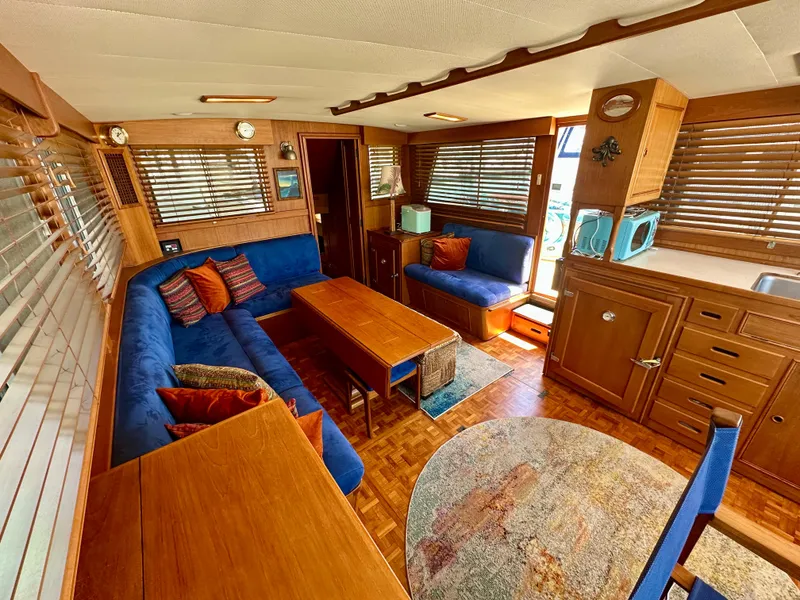 Slide: The Image of Luxurious 1994 Grand Banks 42 Classic yacht interior with blue seating, wooden accents, and nautical decor. - 20