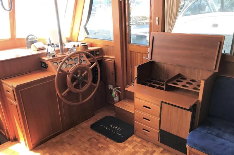 Slide: The Image of 1994 Grand Banks 42 Classic yacht interior with wooden helm and storage compartments. - 29