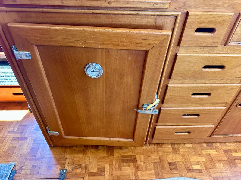 Slide: The Image of Wooden cabinetry inside a 1994 Grand Banks 42 Classic boat, featuring drawers and a door. - 31