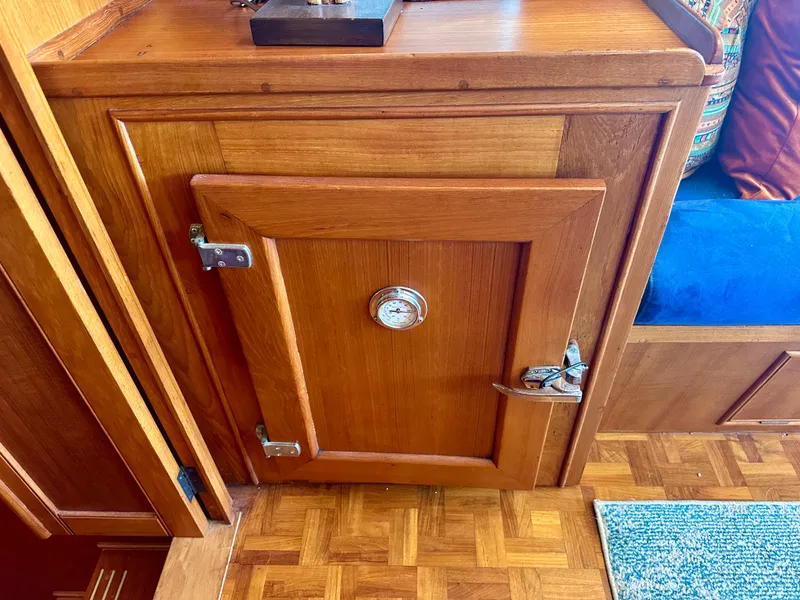 Slide: The Image of Wooden cabinet with a metal latch and gauge on a 1994 Grand Banks 42 Classic boat. - 33