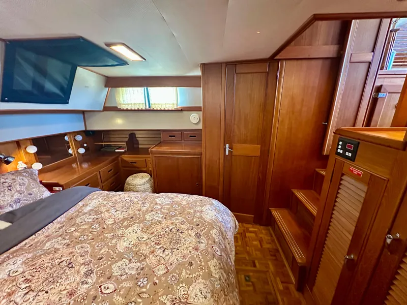 Slide: The Image of Luxurious 1994 Grand Banks 42 Classic yacht cabin with wood paneling and cozy bedding. - 41