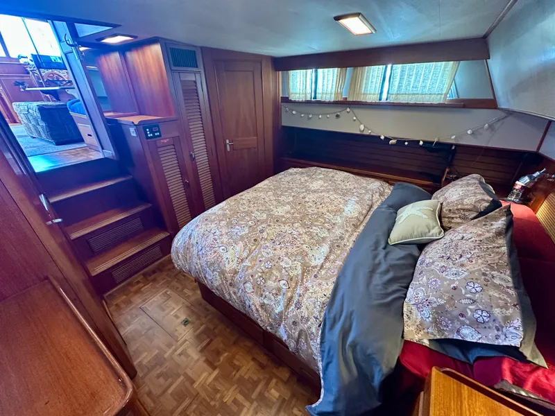 Slide: The Image of Cozy bedroom interior of 1994 Grand Banks 42 Classic yacht with wooden accents and patterned bedding. - 42