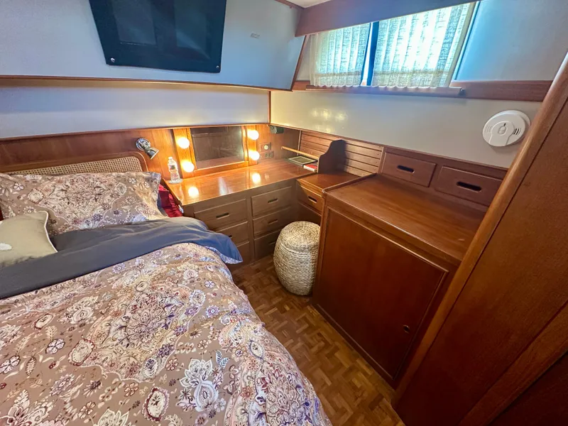 Slide: The Image of Cozy bedroom in 1994 Grand Banks 42 Classic yacht with wood furnishings and floral bedding. - 43