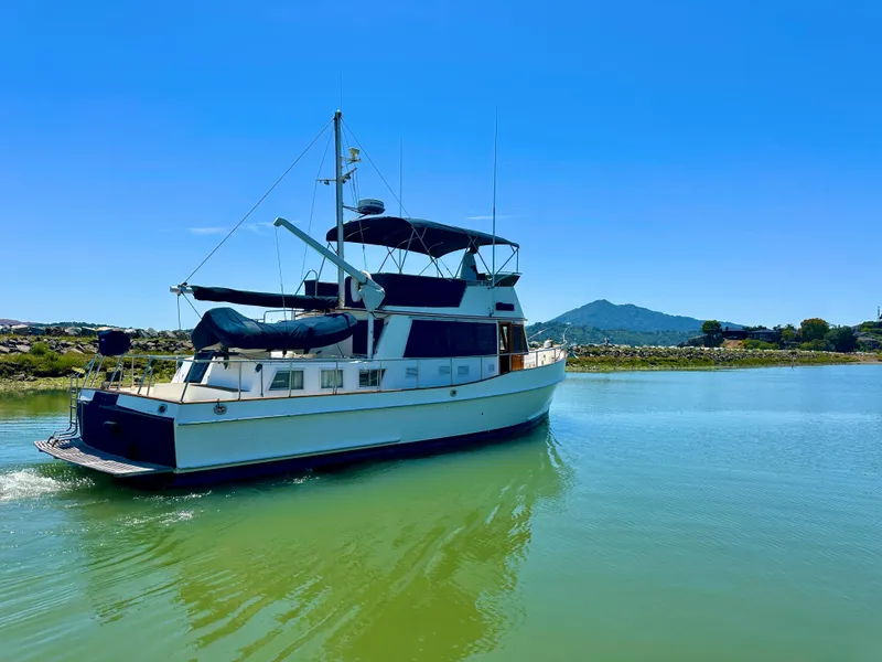 Slide: The Image of Grand Banks 42 Classic yacht from 1994 on calm water under clear blue sky. - 6