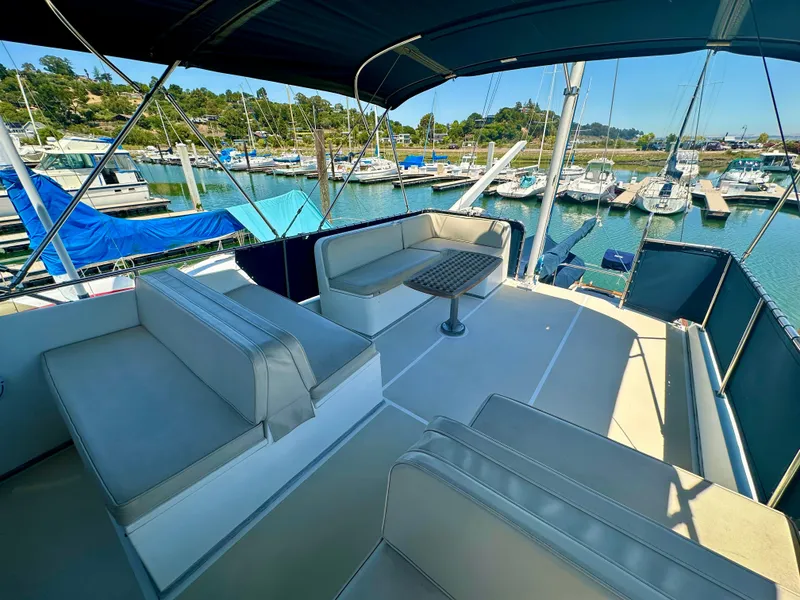 Slide: The Image of Flybridge of 1994 Grand Banks 42 Classic yacht with seating, table, and marina view. - 7