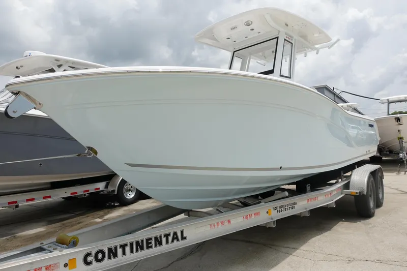The Image of 2025 Sea Fox 248 Commander boat on a Continental trailer, displayed outdoors. - 1