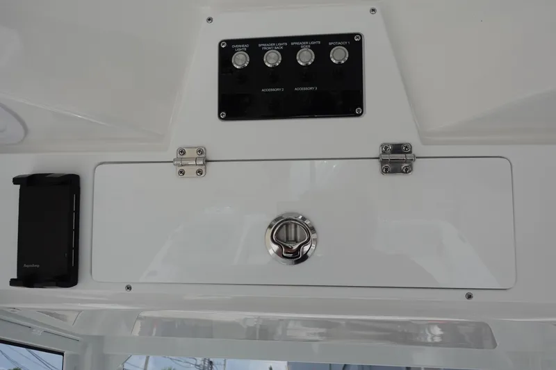 Slide: The Image of 2025 Sea Fox 248 Commander control panel with switches and storage compartment. - 16