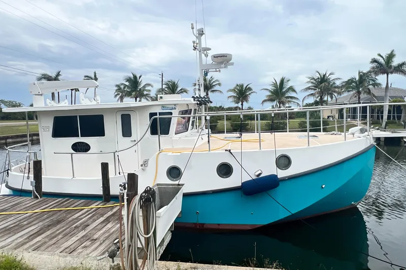 The Image of 2006 Great Harbour N37 boat docked by palm trees under cloudy sky. - 1