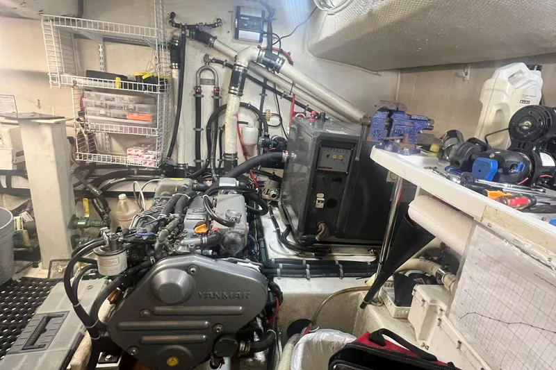 Slide: The Image of Engine room of a 2006 Great Harbour N37 boat, featuring a Yanmar engine and various tools. - 13