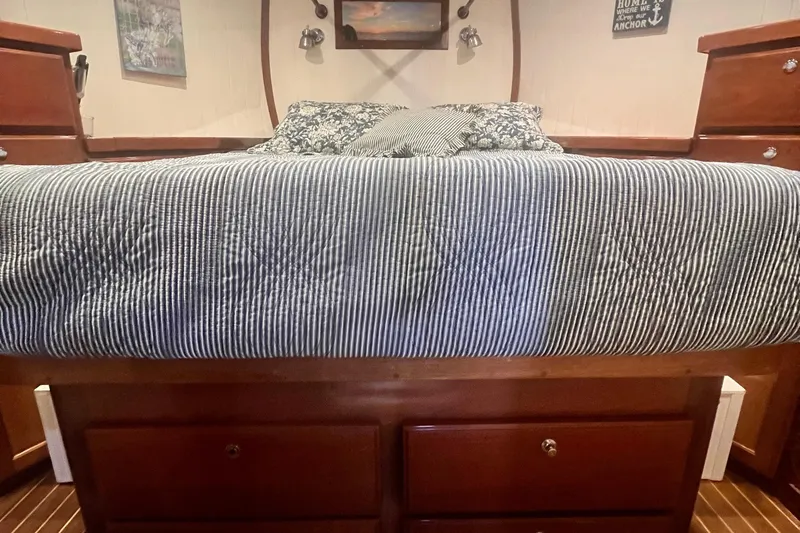 Slide: The Image of Cozy bedroom interior of 2006 Great Harbour N37 boat with striped bedding and wooden storage. - 14