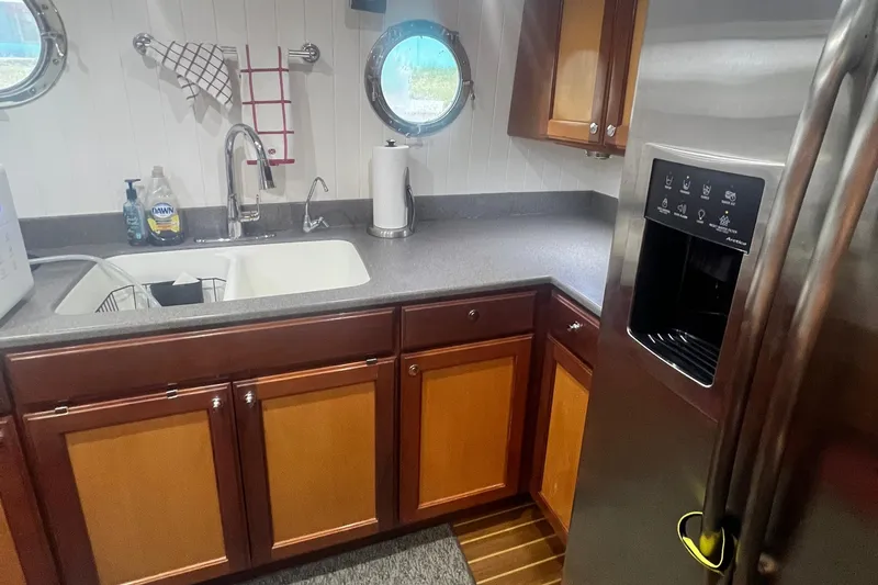 Slide: The Image of Kitchen area of 2006 Great Harbour N37 boat with sink, cabinets, and stainless steel refrigerator. - 16