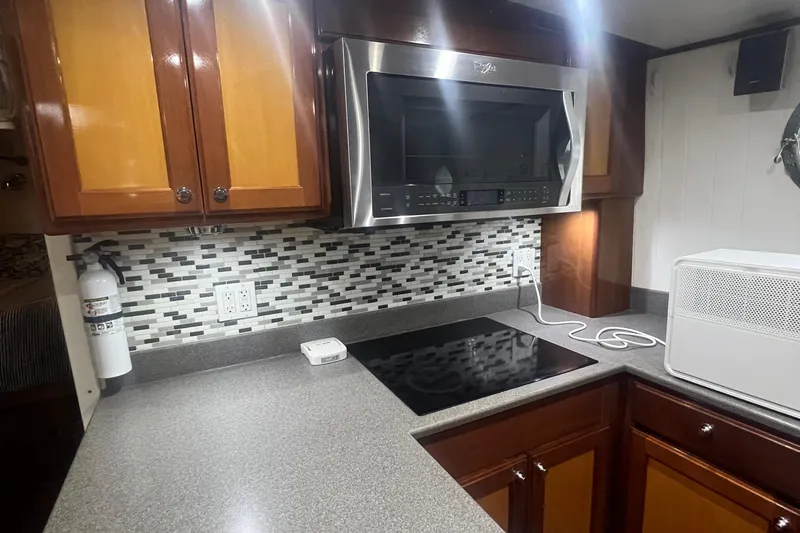 Slide: The Image of Modern kitchen in 2006 Great Harbour N37 boat with microwave, stovetop, and mosaic backsplash. - 20