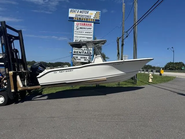 The Image of 2022 Key West 239FS boat on forklift near dealership sign. - 1