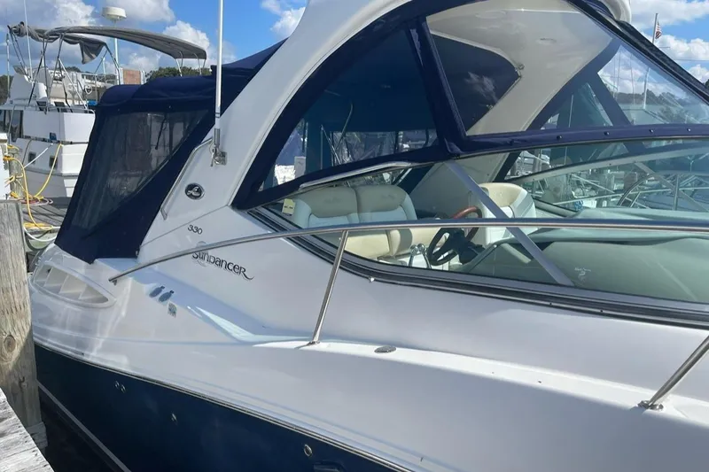 Slide: The Image of 2008 Sea Ray 330 Sundancer yacht docked, featuring sleek design and blue canopy. - 1