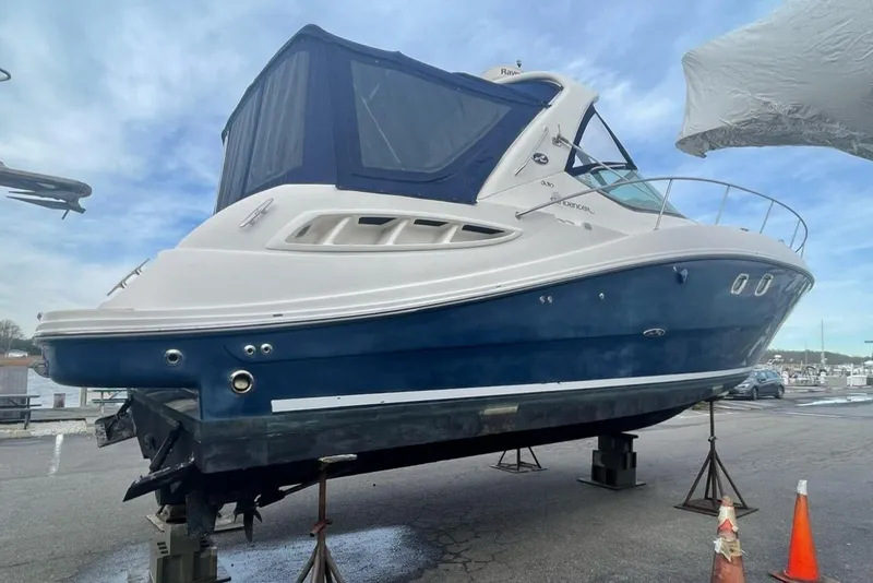 Slide: The Image of 2008 Sea Ray 330 Sundancer boat on stands, blue and white exterior, marina background. - 10