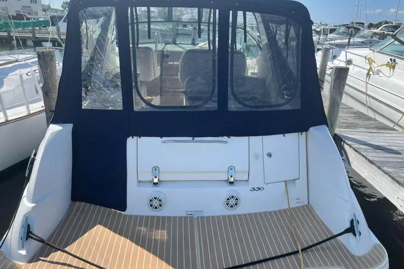 Slide: The Image of 2008 Sea Ray 330 Sundancer boat docked, rear view with covered seating area. - 4