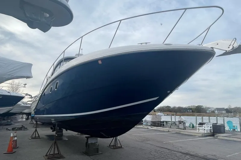 Slide: The Image of 2008 Sea Ray 330 Sundancer yacht on stands, marina background, overcast sky. - 6