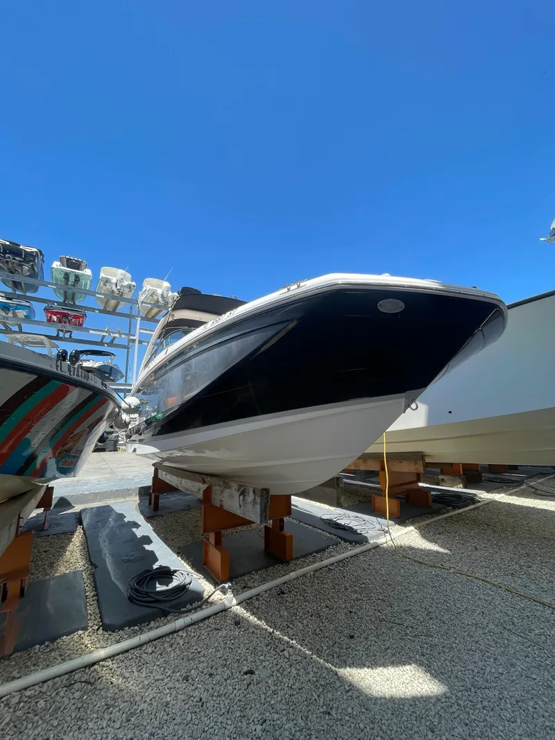 Slide: The Image of 2021 Regal 260BX boat on display under clear blue sky. - 2