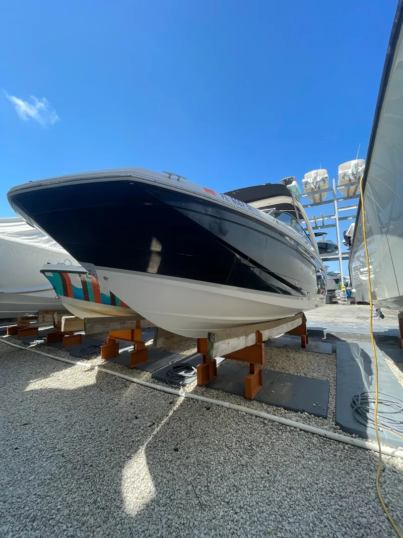 Slide: The Image of 2021 Regal 260BX boat on display under clear blue sky. - 3