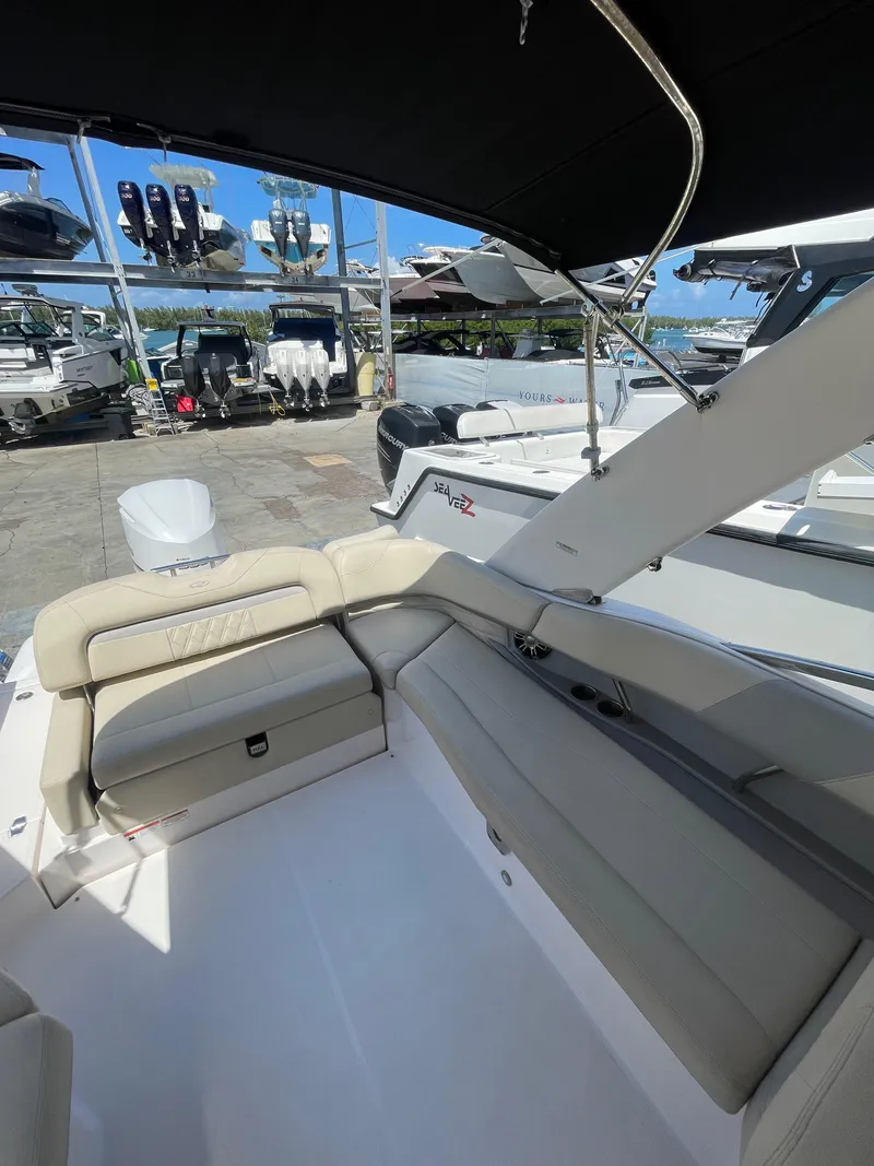 Slide: The Image of 2021 Regal 260BX boat interior with beige seating, docked at a marina. - 4