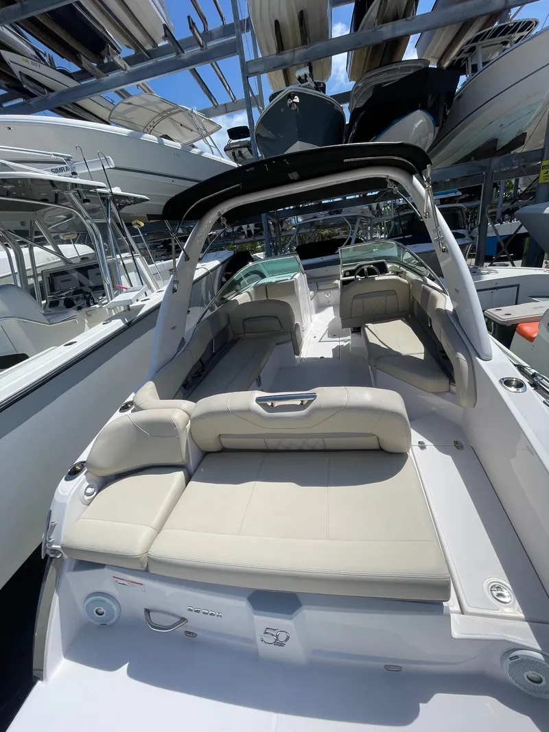 Slide: The Image of 2021 Regal 260BX boat with spacious seating, docked in a marina. - 5
