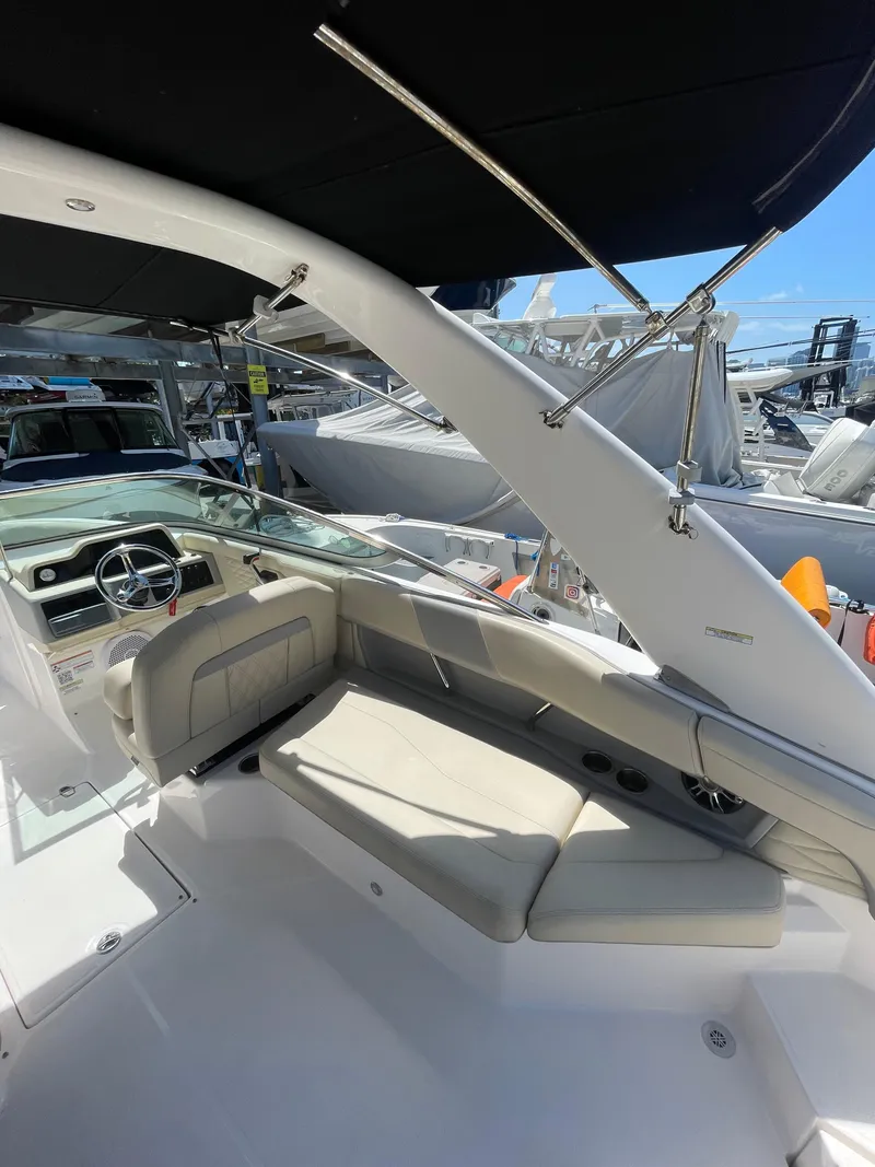 Slide: The Image of 2021 Regal 260BX boat interior with seating and steering wheel under a black canopy. - 6