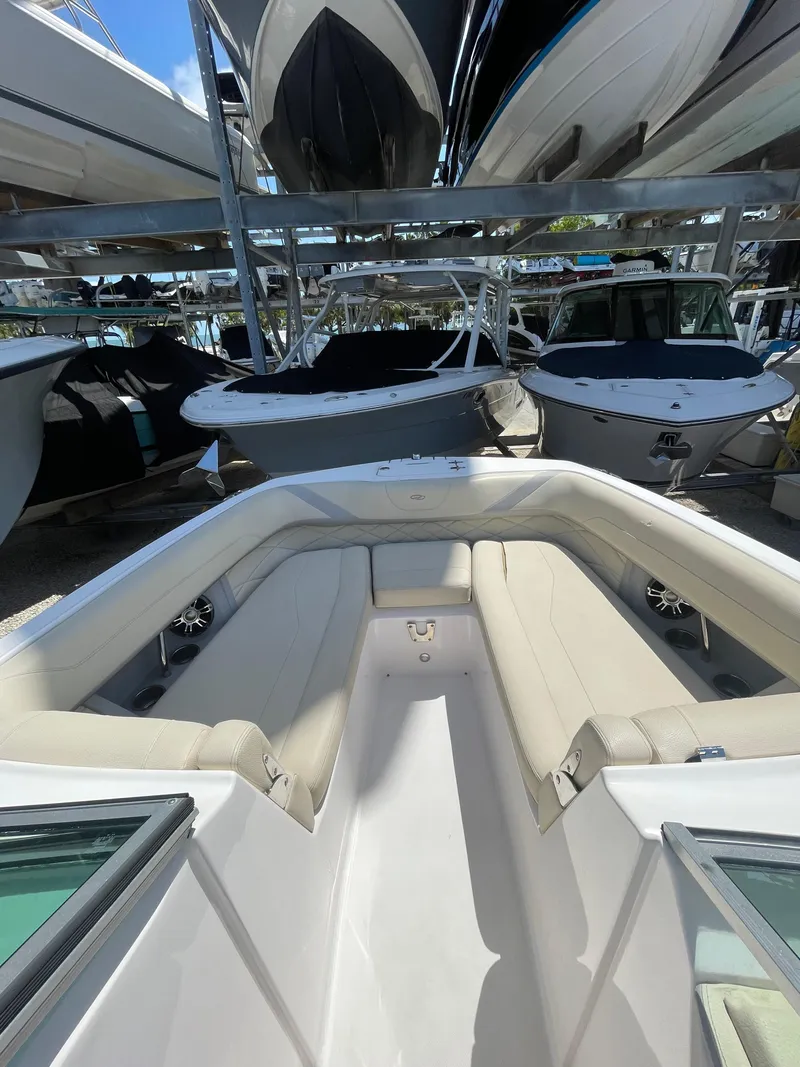 Slide: The Image of 2021 Regal 260BX boat with beige seating, docked among other boats. - 8