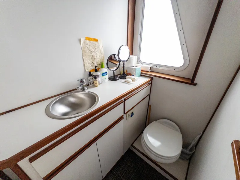 Slide: The Image of Compact bathroom in 1986 Custom Expedition Vessel 58 with sink, toilet, and window. - 13