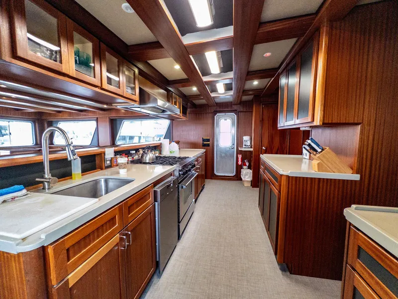 Slide: The Image of Luxurious kitchen interior of 1986 Custom Expedition Vessel 58 with wooden cabinetry and modern appliances. - 16