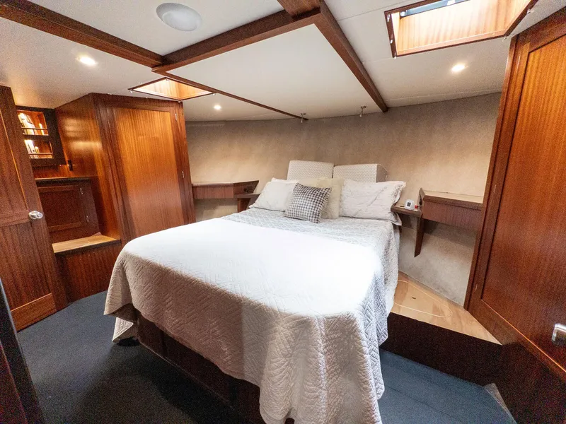 Slide: The Image of Luxurious cabin interior of 1986 Custom Expedition Vessel 58 with cozy bed and wooden accents. - 19