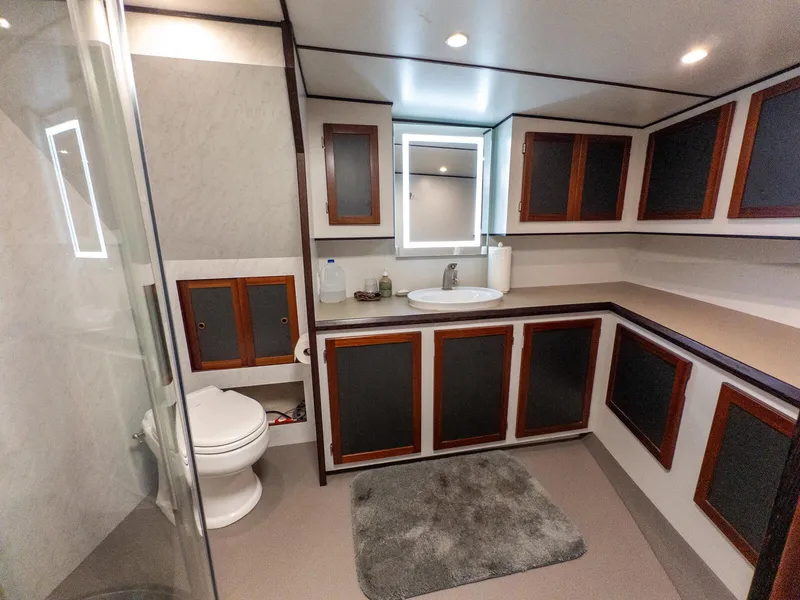 Slide: The Image of Luxurious bathroom in 1986 Custom Expedition Vessel 58 with modern fixtures and wooden cabinetry. - 21