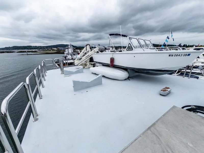 Slide: The Image of Custom Expedition Vessel 58 (1986) with small boat on deck, moored in a marina. - 33