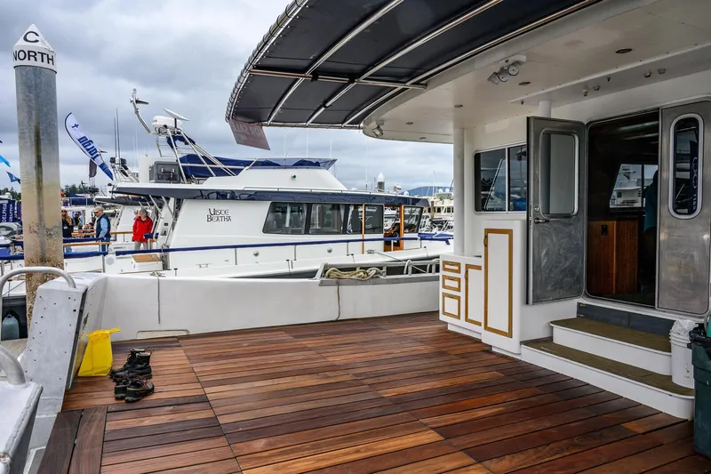 Slide: The Image of Expedition Vessel 58, 1986 model, docked with wooden deck and nearby boats. - 5