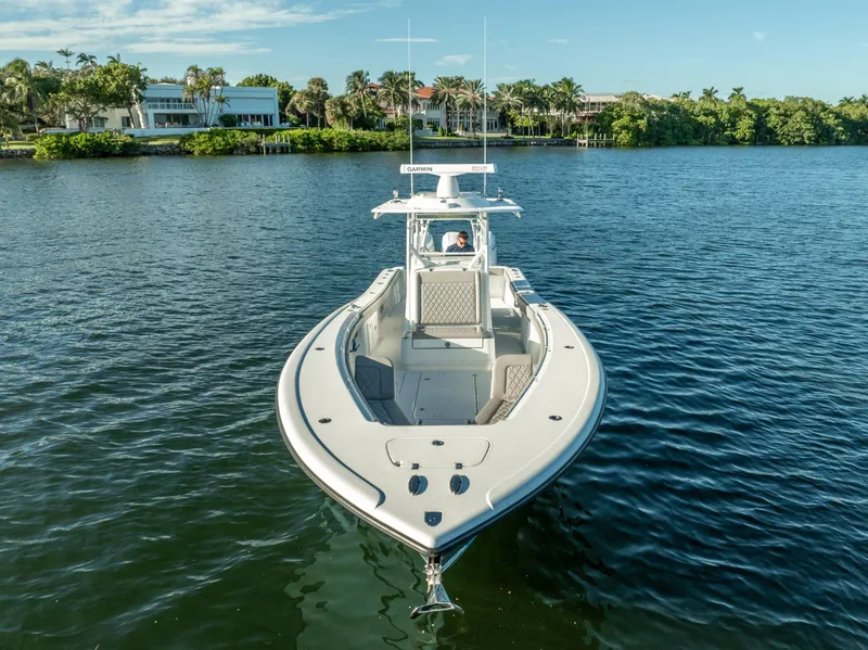 Slide: The Image of 2023 Yellowfin 36 boat on calm water with scenic waterfront background. - 14