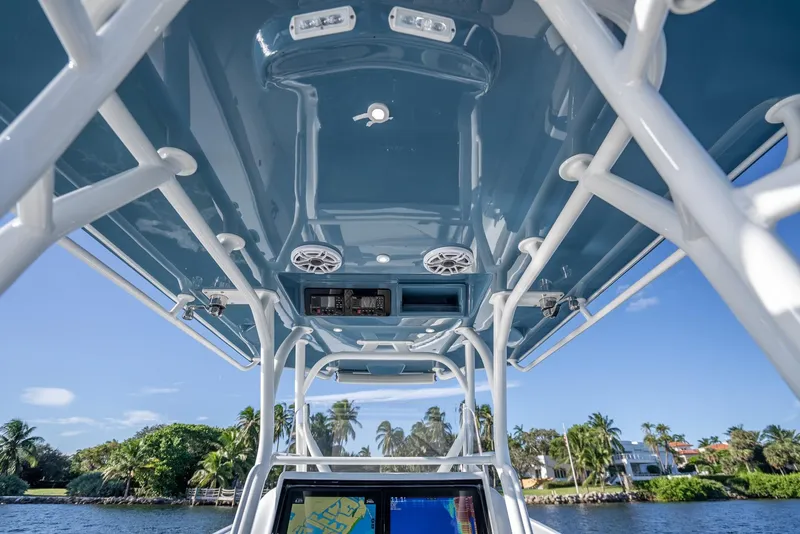 Slide: The Image of 2023 Yellowfin 36 boat interior with blue ceiling and speakers, set against a scenic waterfront. - 24