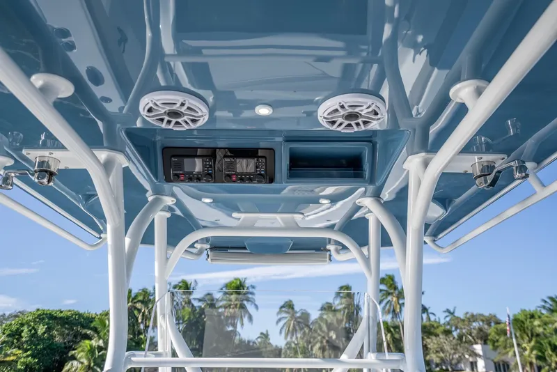 Slide: The Image of 2023 Yellowfin 36 boat console with speakers and electronics, set against a tropical backdrop. - 25