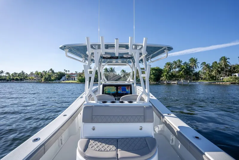 Slide: The Image of 2023 Yellowfin 36 boat on calm water, clear sky, and lush shoreline. - 28