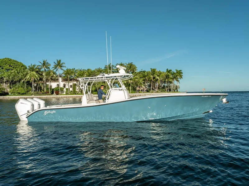 Slide: The Image of 2023 Yellowfin 36 boat on water, clear sky, palm trees in background. - 8