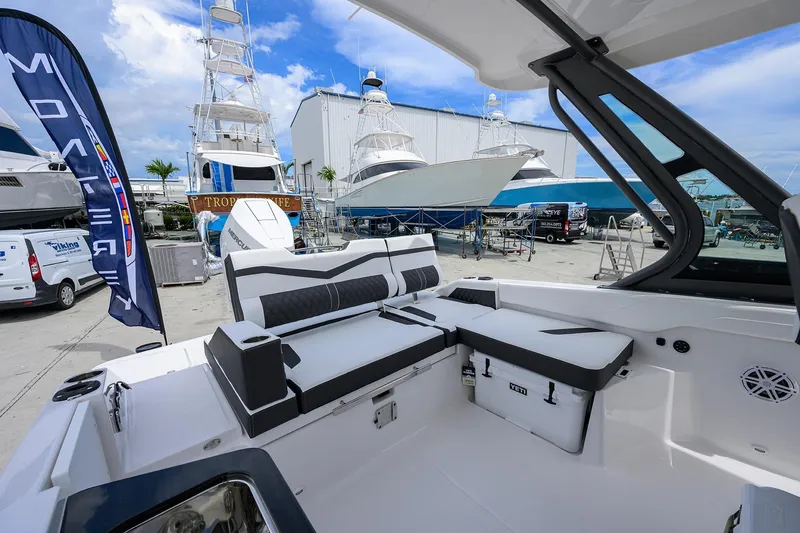 Slide: The Image of 2026 Monterey Elite 27 OB boat interior at marina with yachts and blue sky. - 10